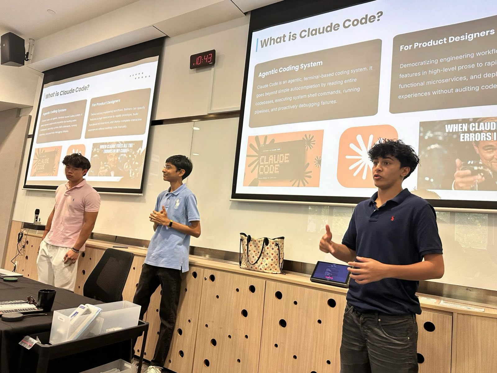 One of the three instructors explaining a slide titled What is Claude Code? while the other two stand to one side.