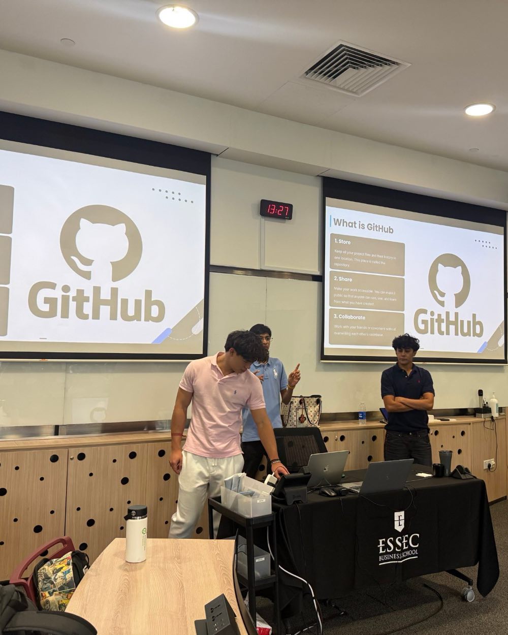 The team at the lectern under two screens showing the GitHub logo.